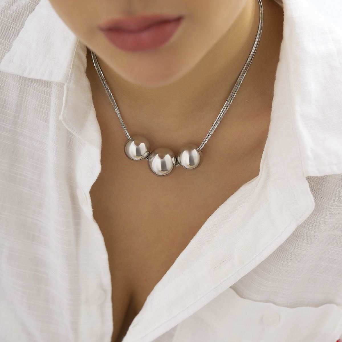 Collar multicapa con bola geométrica en dorado y plateado
