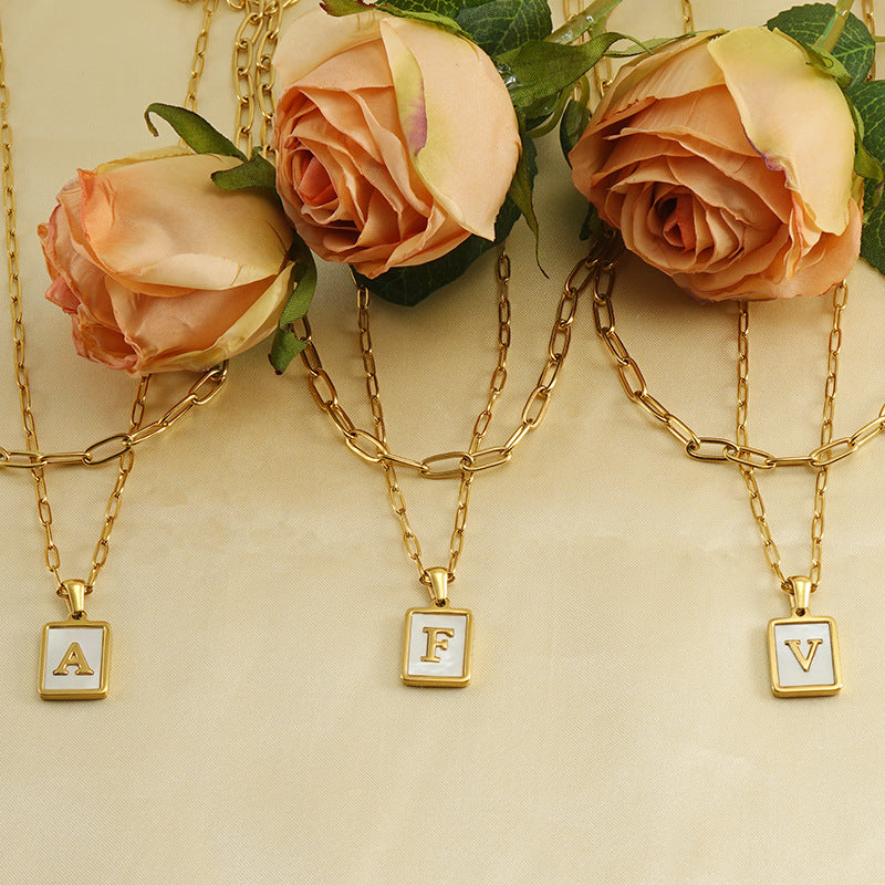 Collar con letras con fondo de concha nacar con clip de acero inoxidable , baño dorado de calidad