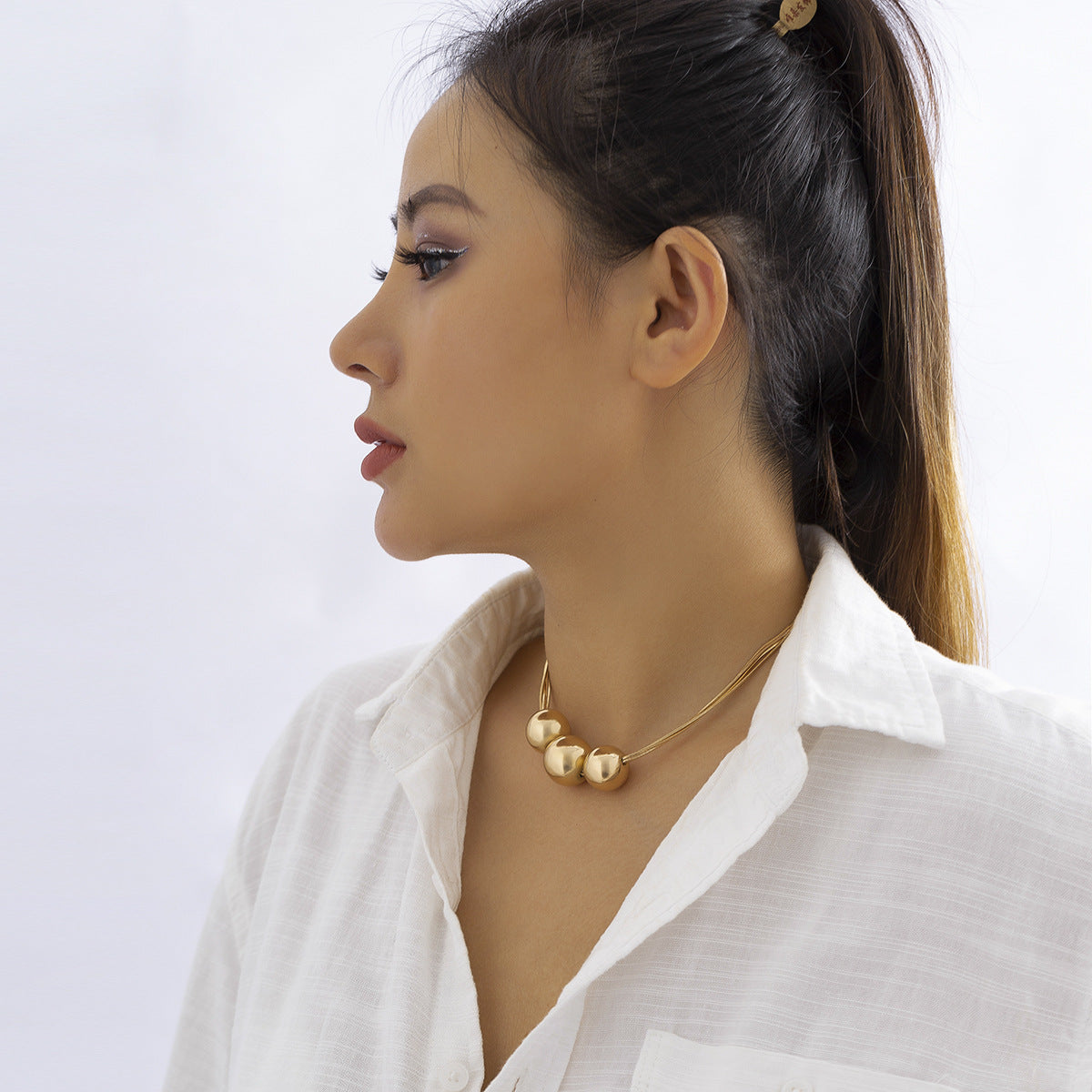 Collar multicapa con bola geométrica en dorado y plateado