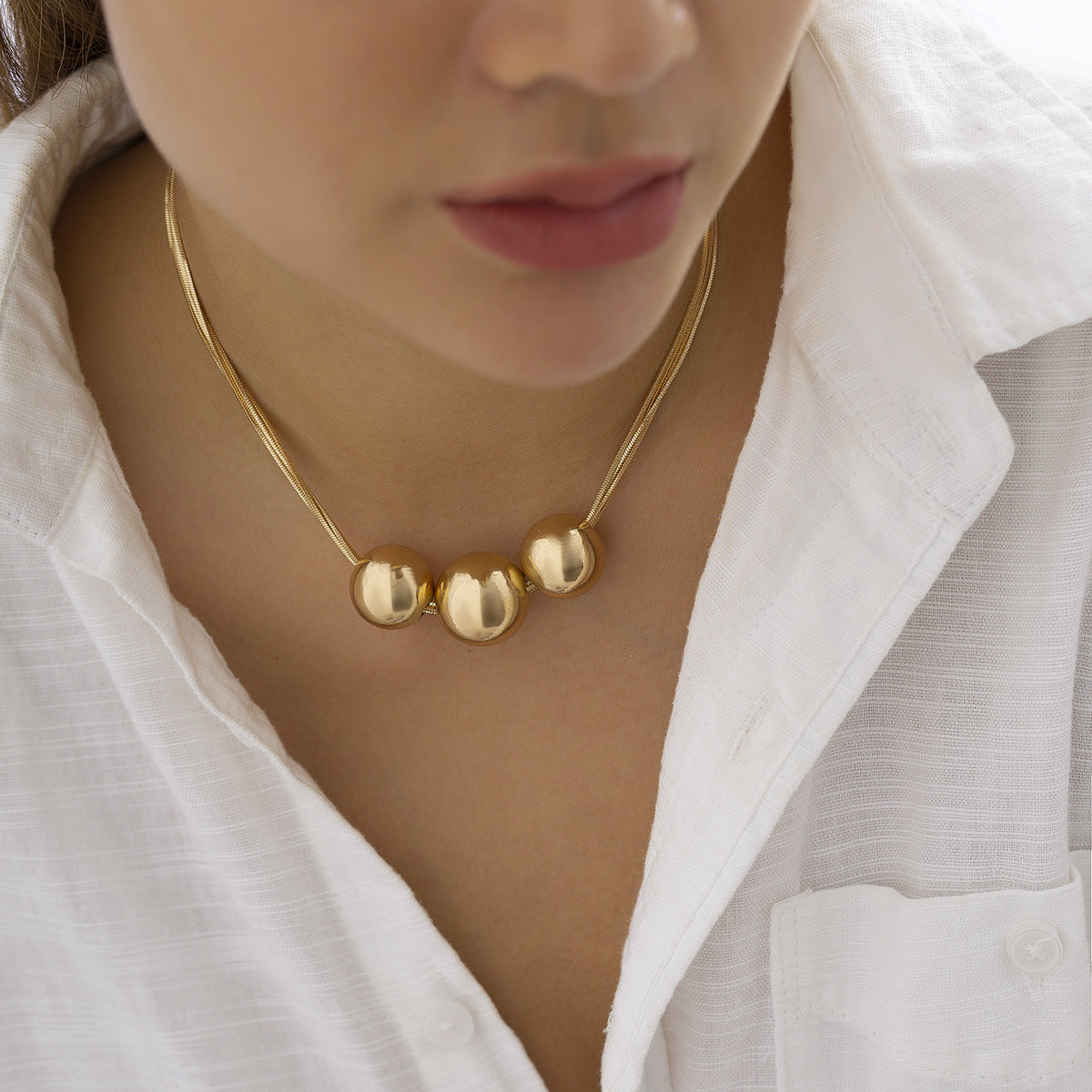 Collar multicapa con bola geométrica en dorado y plateado