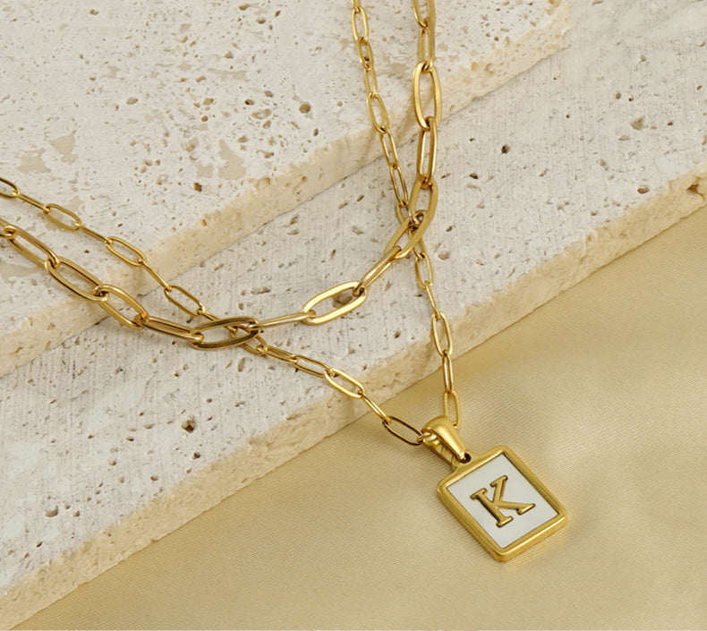 Collar con letras con fondo de concha nacar con clip de acero inoxidable , baño dorado de calidad