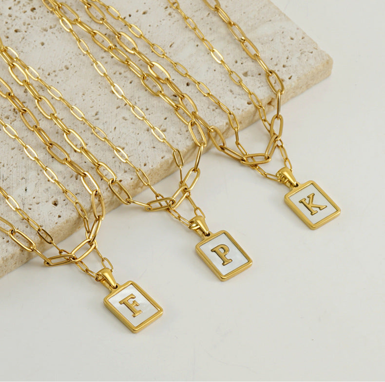 Collar con letras con fondo de concha nacar con clip de acero inoxidable , baño dorado de calidad