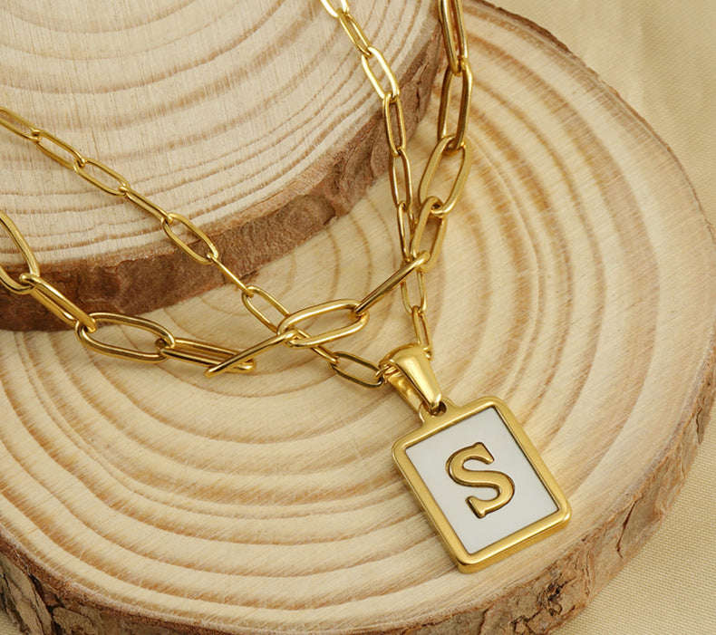 Collar con letras con fondo de concha nacar con clip de acero inoxidable , baño dorado de calidad