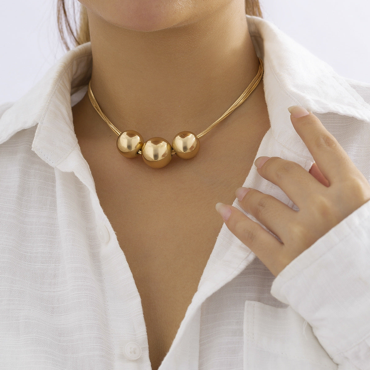 Collar multicapa con bola geométrica en dorado y plateado