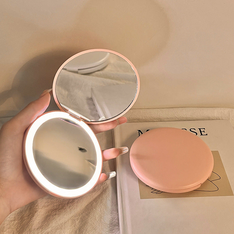 Espejo cosmético portátil con luz LED para maquillaje.