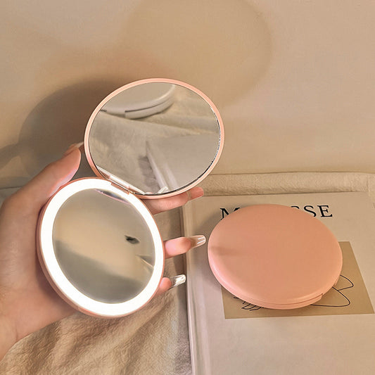 Espejo cosmético portátil con luz LED para maquillaje.