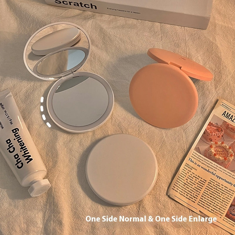 Espejo cosmético portátil con luz LED para maquillaje.
